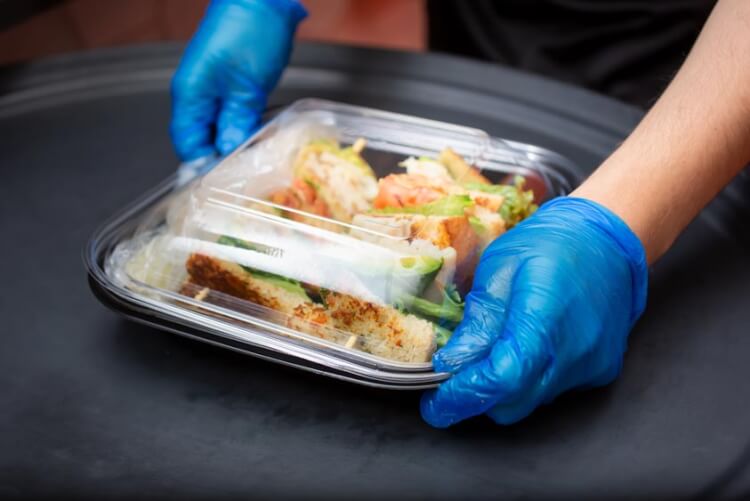 Close up van blauwe wegwerphandschoenen bij sushi