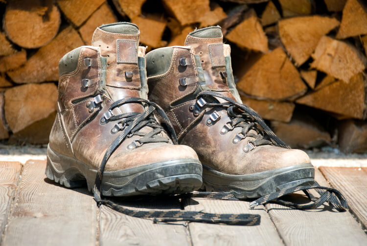 Twee bruine hoge werkschoenen staan voor blokken hout